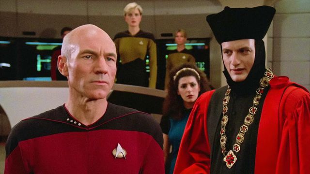 John de Lancie in his judge costume from the Star Trek: The Next Generation episode “Encounter at Farpoint” faces Jean-Luc Picard