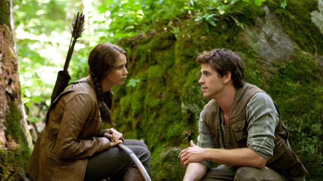 Jennifer Lawrence as Katniss Everdeen and Liam Hemsworth as Gale Hawthorne pause together in the forest in The Hunger Games
