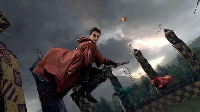 Harry Potter flying on a broom in his quidditch uniform
